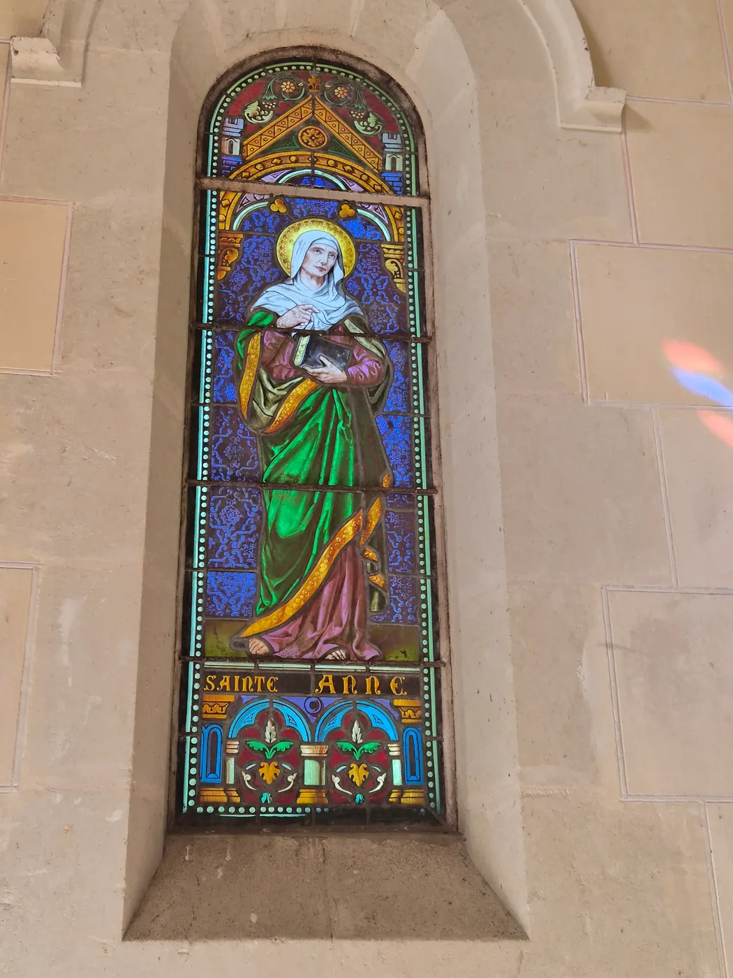 Le vitrail de sainte Anne, l'un des vitraux à personnages de la chapelle.